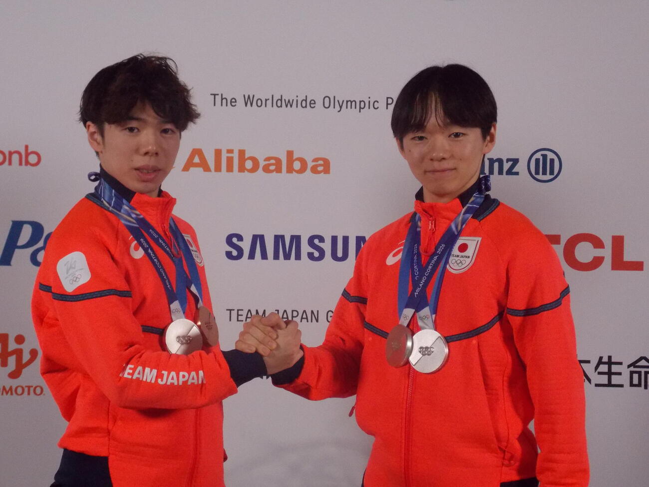 日本オリンピック委員会（JOC）のメダリスト記者会見で健闘をたたえ合う鍵山優真（右）と佐藤駿（撮影・松本航）