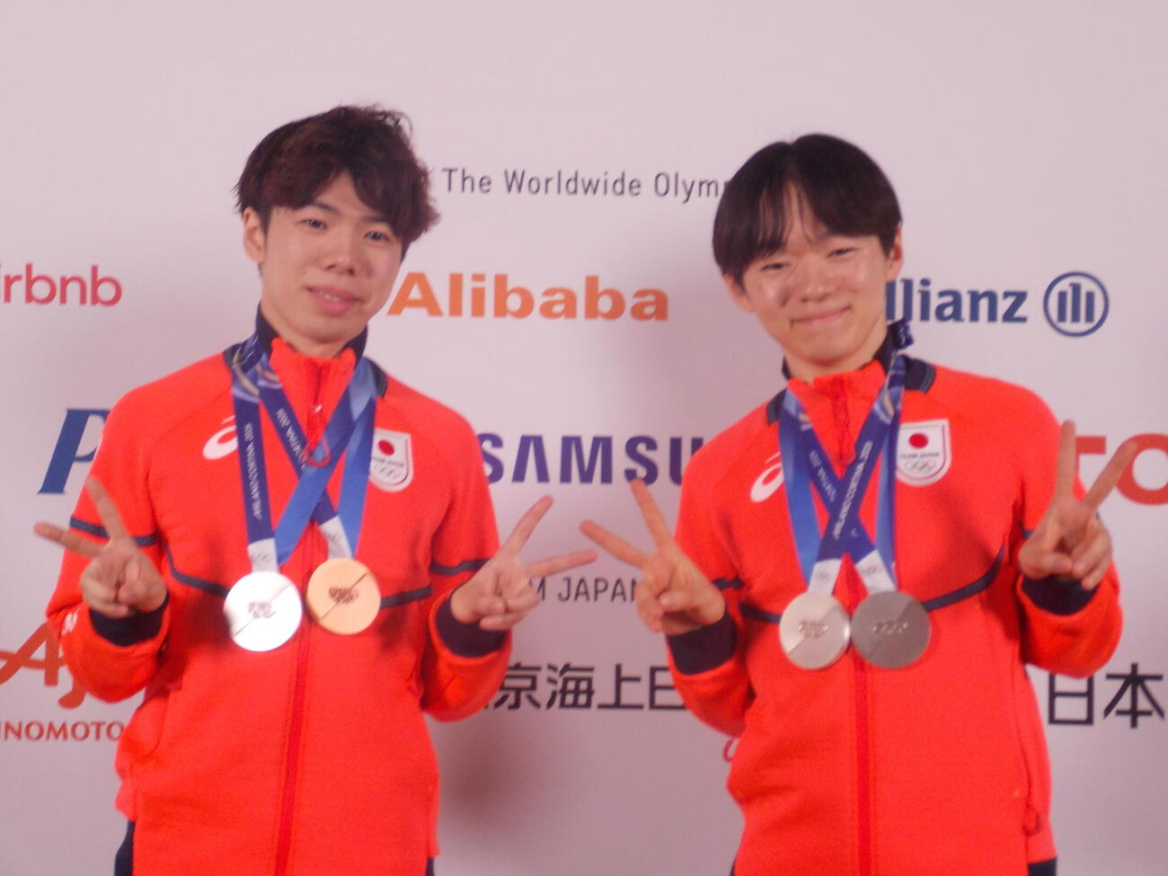 日本オリンピック委員会（JOC）のメダリスト記者会見でメダル2個獲得を表現する鍵山優真（右）と佐藤駿（撮影・松本航）