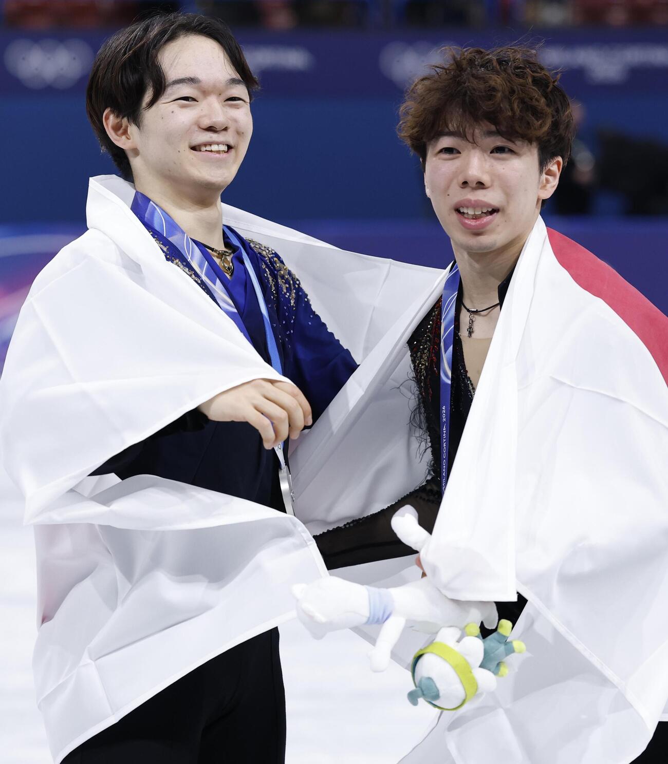 表彰式後、男子で銅メダルの佐藤駿（右）と喜び合う銀メダルの鍵山優真（共同）