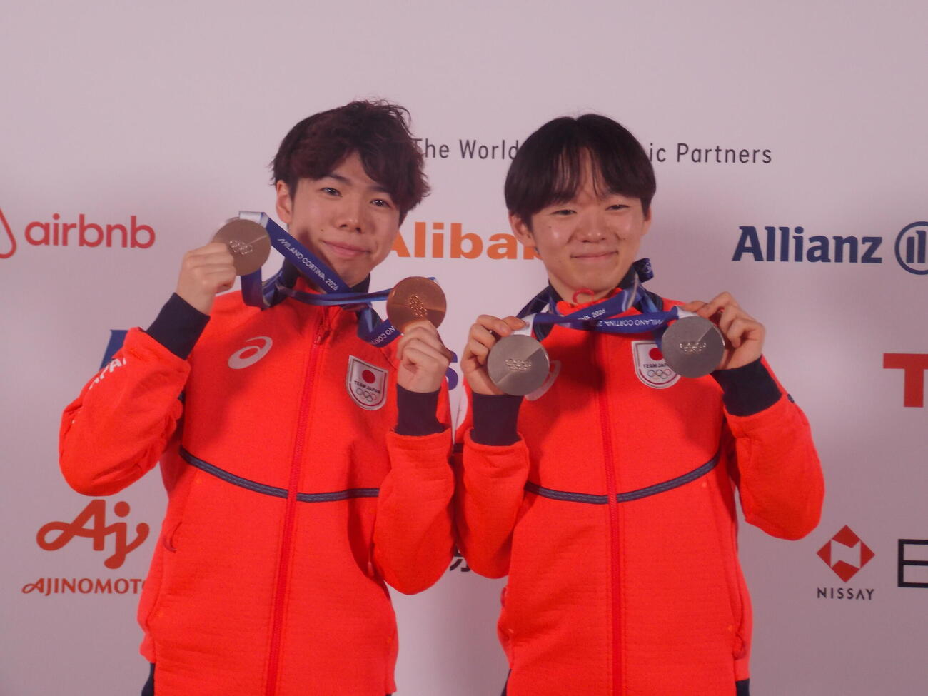 日本オリンピック委員会（JOC）のメダリスト記者会見で笑顔を見せる鍵山優真（右）と佐藤駿（撮影・松本航）