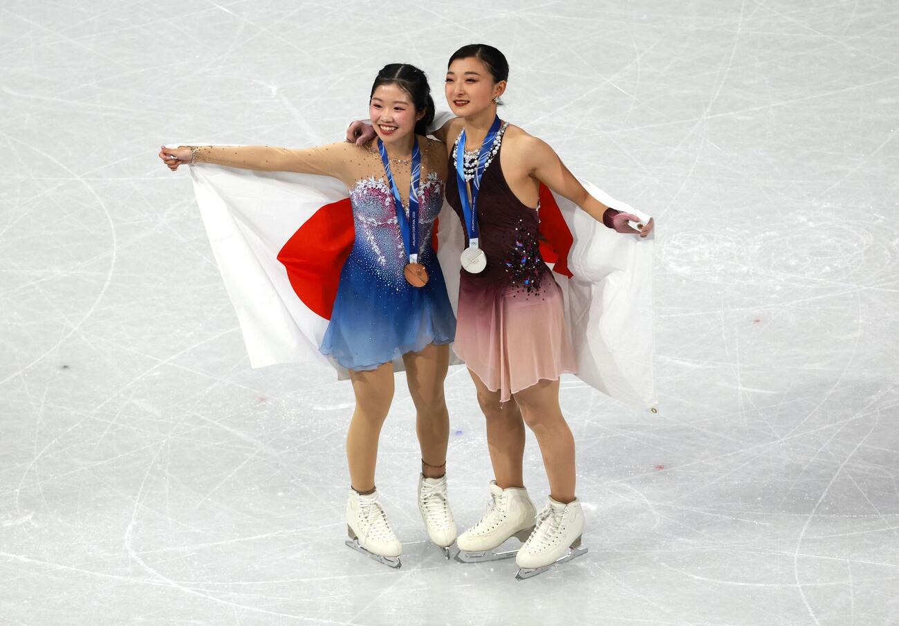 日の丸を掲げる銀メダルの坂本花織と銅メダルの中井亜美（ロイター）