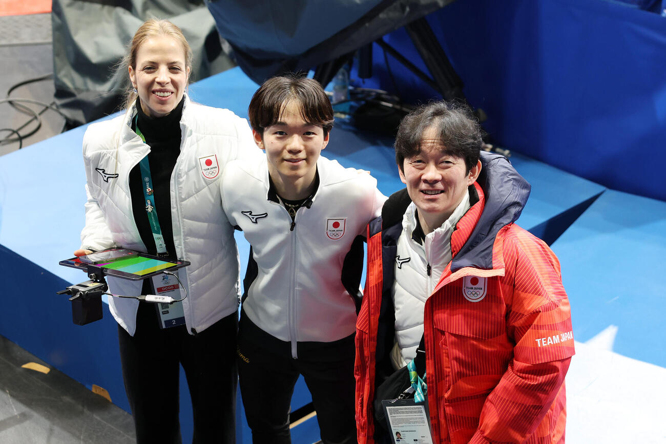 5日、公式練習を終え笑顔で写真に納まる鍵山（中央）。左はカロリーナ・コストナー・コーチ、右は父正和コーチ（撮影・前田充）