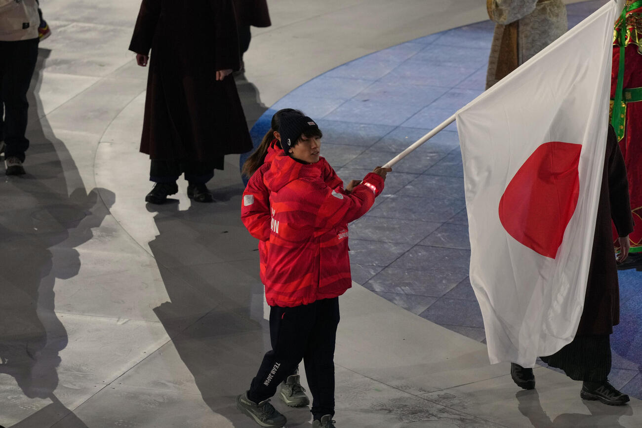 日の丸を手に入場した旗手の坂本と森重（AP)