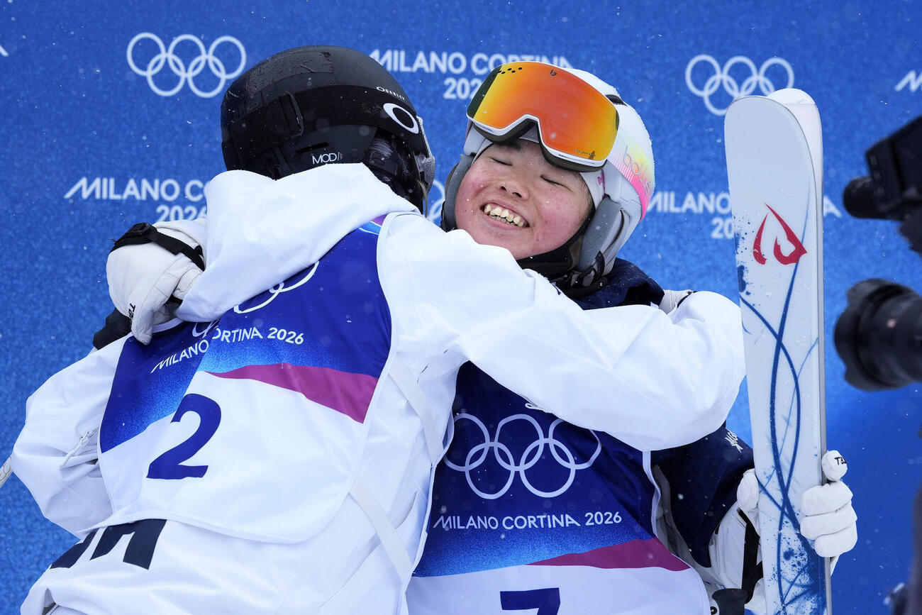 女子デュアルモーグル準々決勝で敗退し、健闘をたたえ合う冨高日向子（共同）