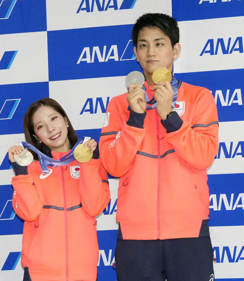 帰国しメダルを手に写真に納まるフィギュアスケート・ペアの三浦（左）と木原（撮影・小島史椰）
