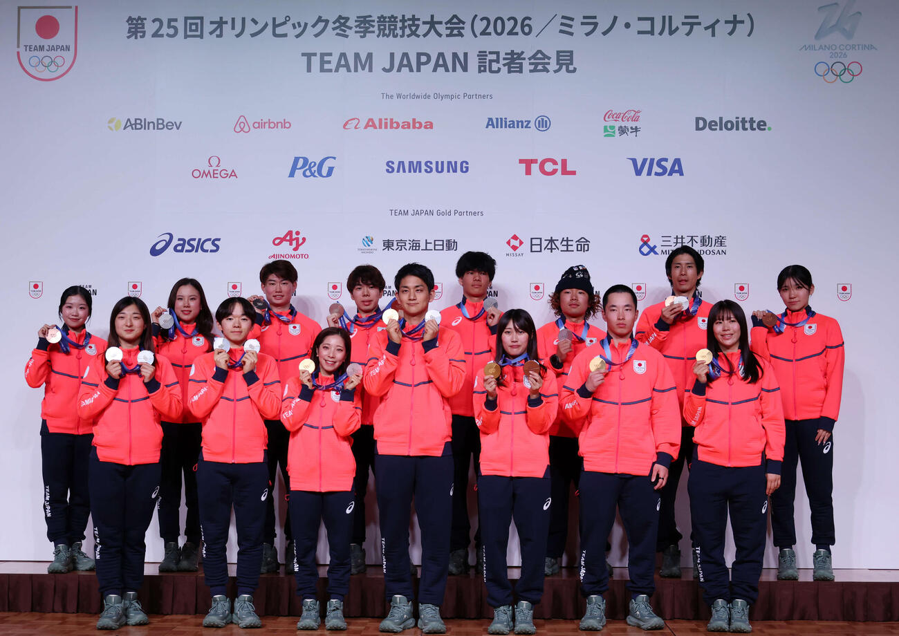 帰国時記者会見で笑顔を見せる選手団。前列左から坂本、鍵山、三浦、木原、村瀬、木村、深田、後列左から中井、吉田、森田、佐藤、木俣、長谷川、堀島、野明（撮影・増田悦実）