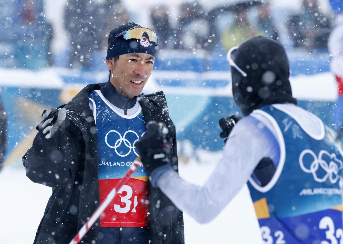 男子団体スプリントの後半距離で、ゴールした山本涼太（右）を迎える渡部暁斗＝テーゼロ（共同）