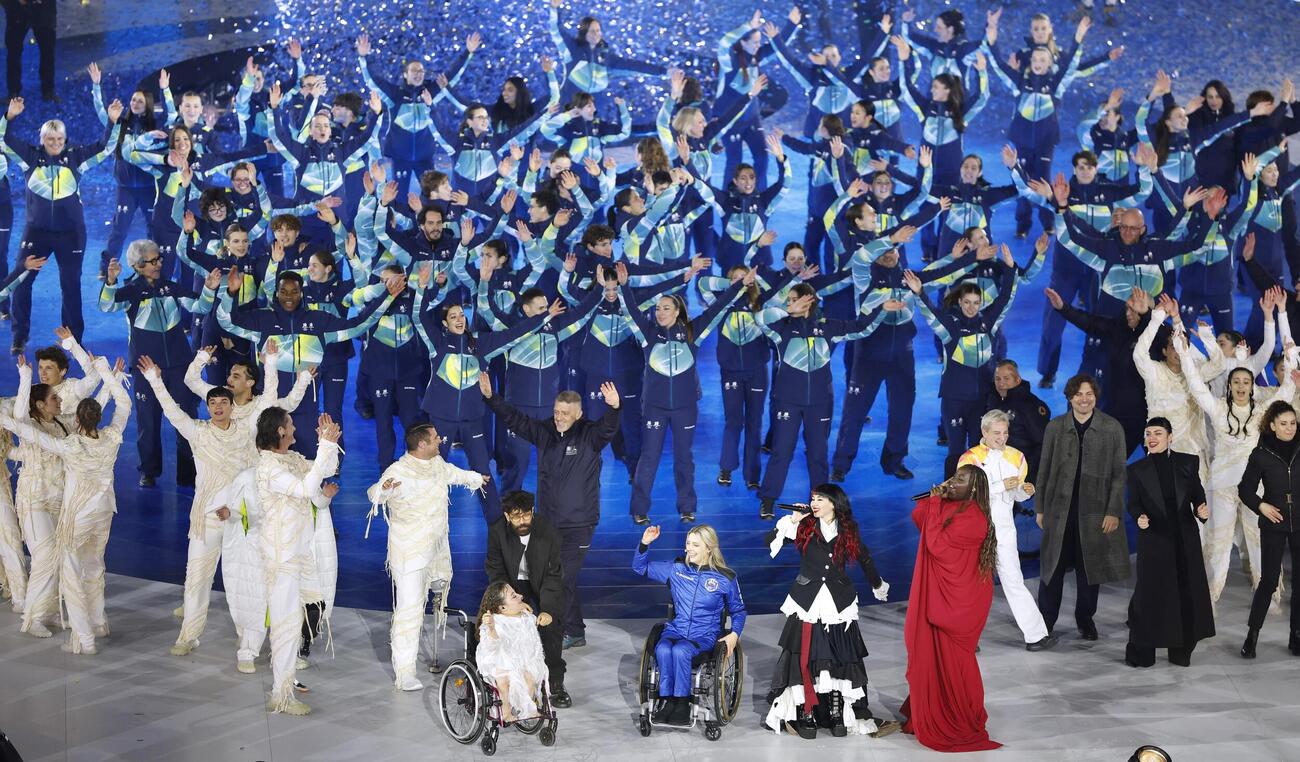 ミラノ・コルティナ冬季パラリンピックの開会式で盛り上がる人たち（共同）