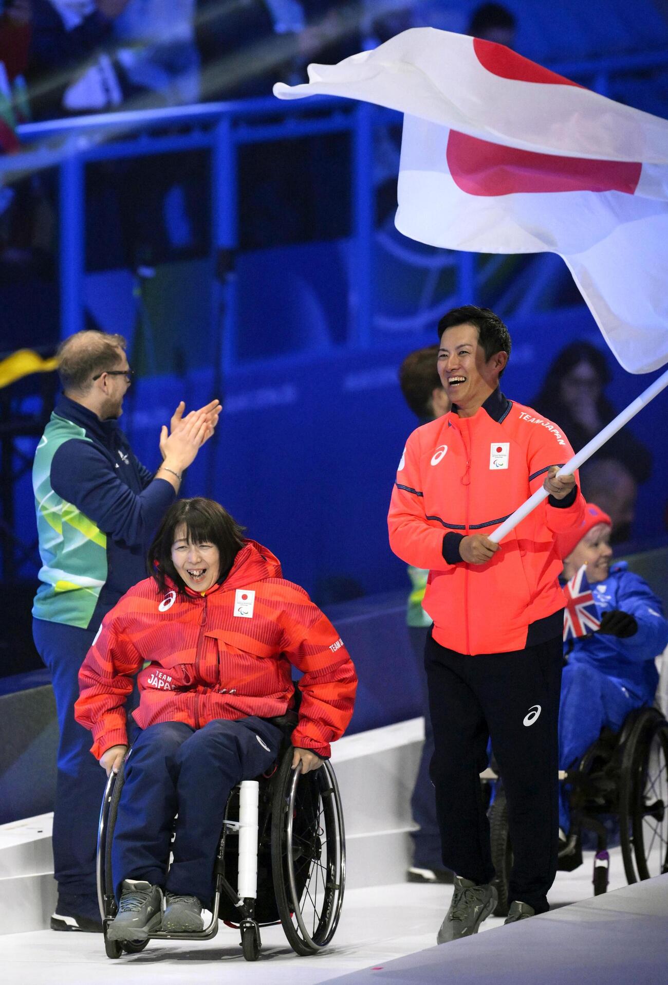 ミラノ・コルティナ冬季パラリンピックの閉会式で入場する、旗手の小川亜希（左）と小須田潤太（共同）