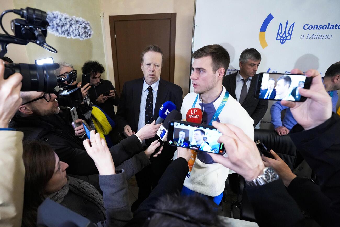 記者会見を終え、報道陣に囲まれるスケルトン男子ウクライナ代表のウラジスラフ・ヘラスケビッチ（中央）（共同）