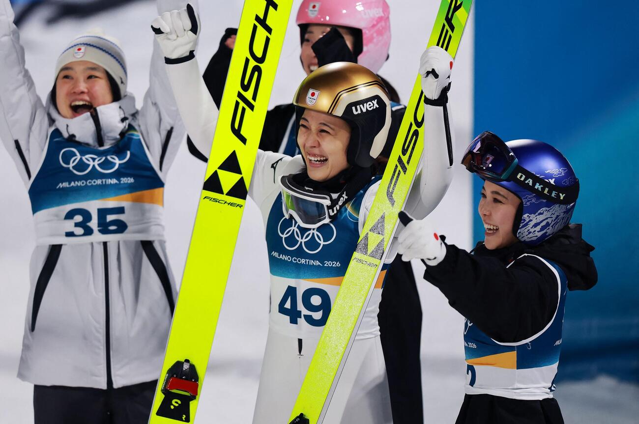 スキージャンプ女子ノーマルヒルで銅メダルを獲得した丸山希(中央)は高梨沙羅(右)らと喜び合う(ロイター)