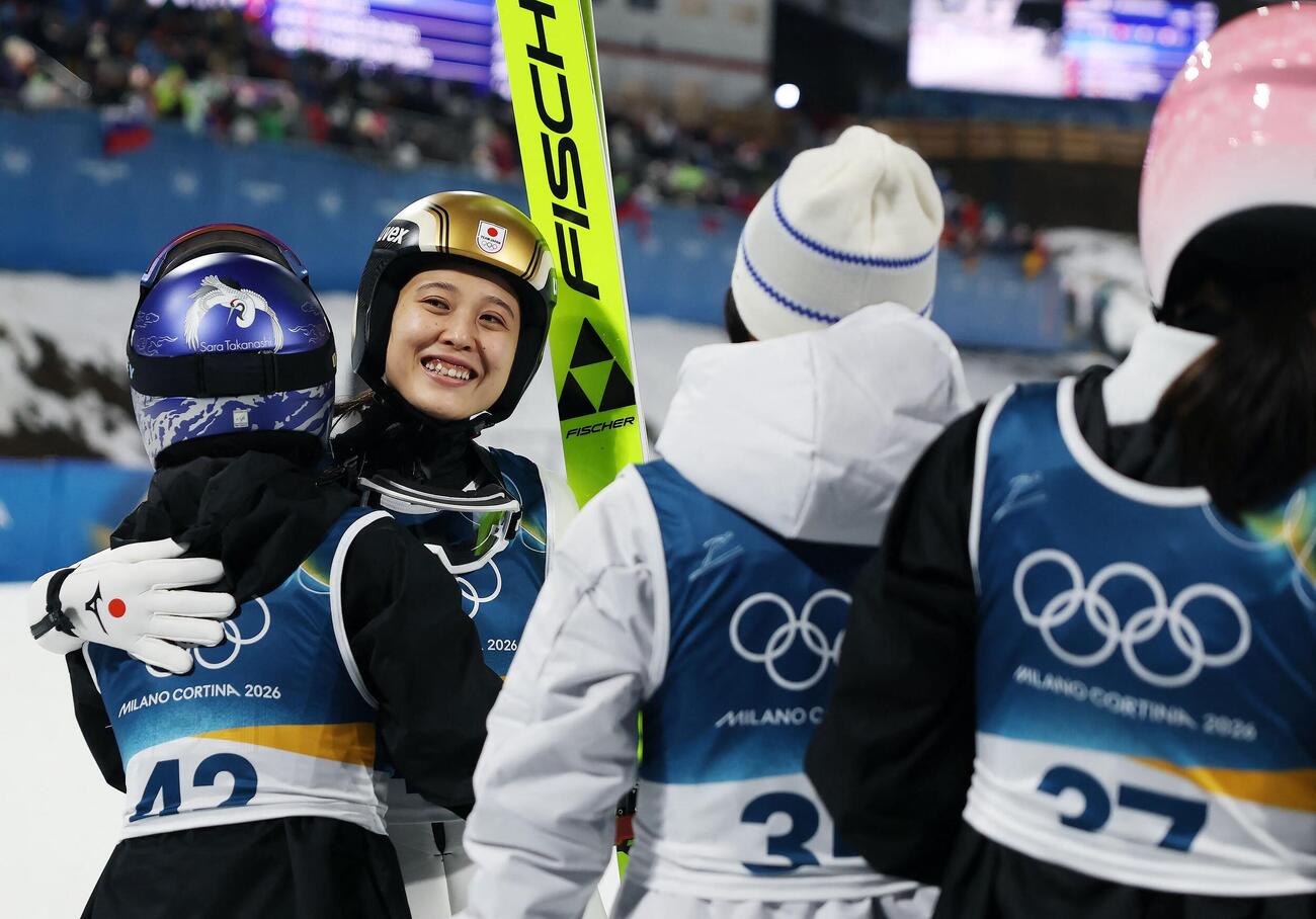 スキージャンプ女子ノーマルヒルで銅メダルを獲得し、高梨沙羅(左)らと抱き合う丸山希(ロイター)