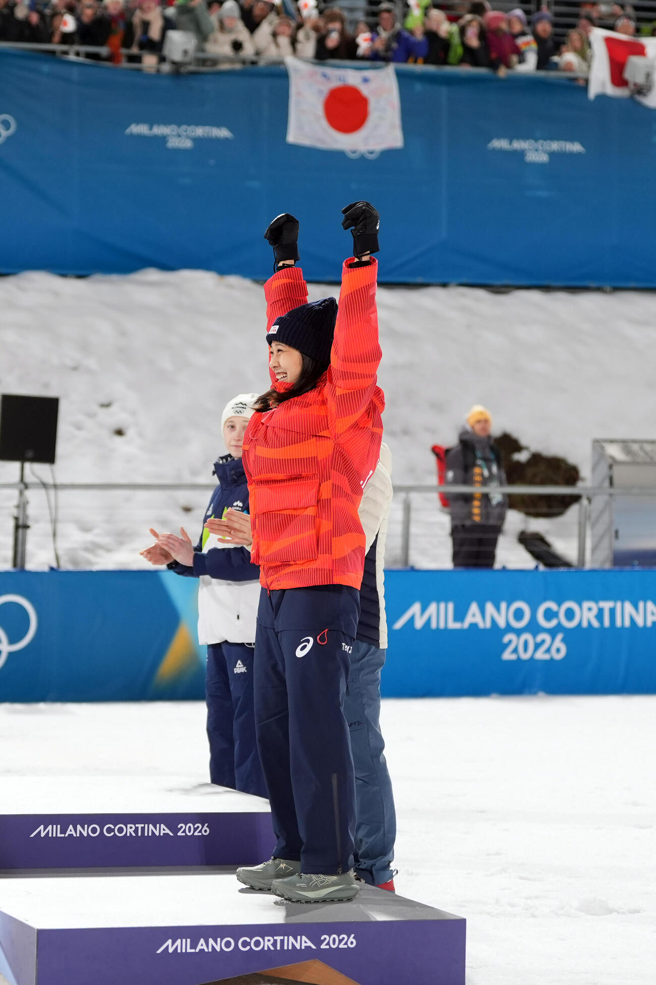 女子個人ノーマルヒル決勝で銅メダルを獲得した丸山希は表彰台でガッツポーズ（撮影・パオロ　ヌッチ）