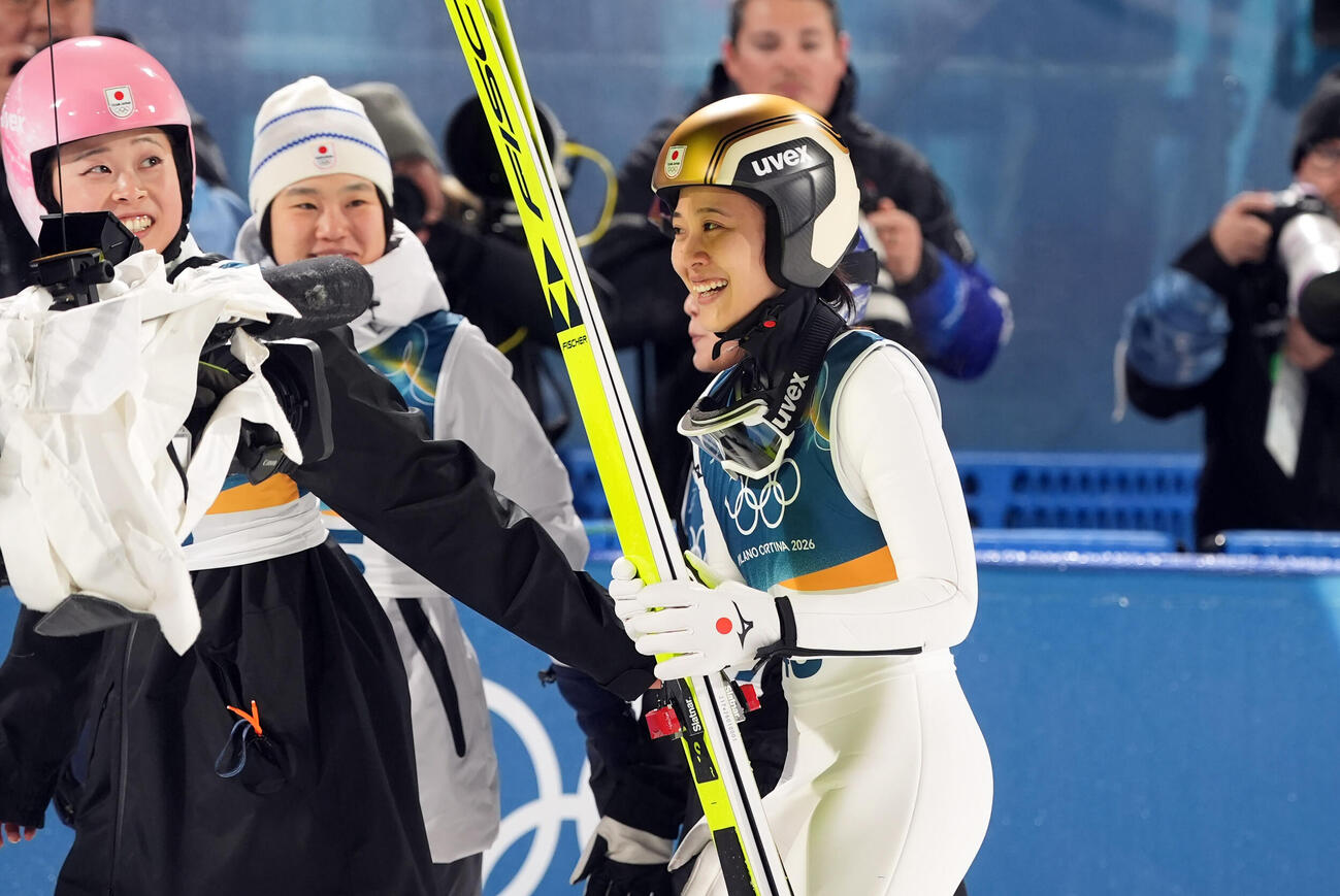 女子個人ノーマルヒル決勝で銅メダルを獲得し笑顔を見せる丸山希。左は勢藤（撮影・パオロ　ヌッチ）
