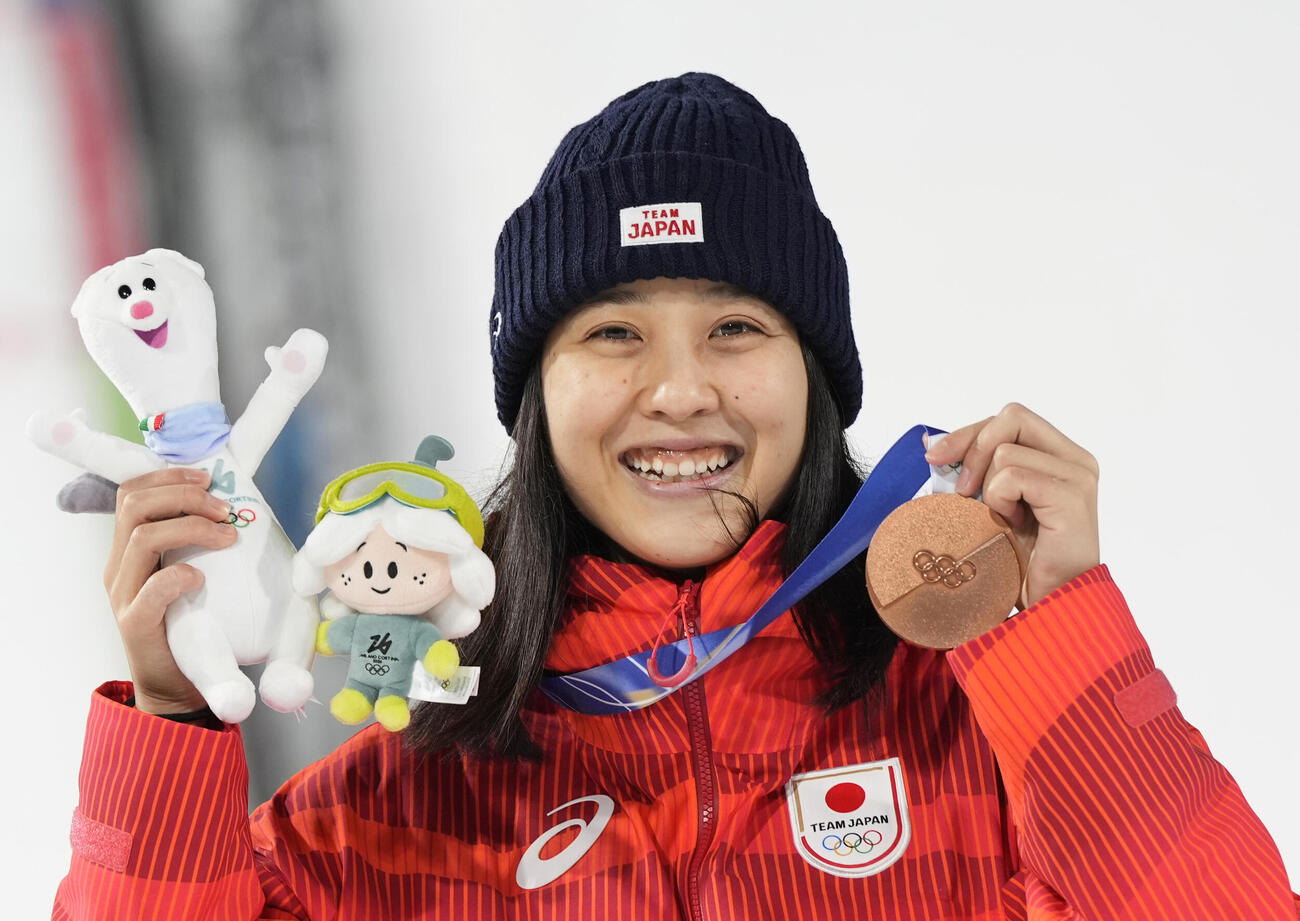 ミラノ・コルティナ五輪スキージャンプ女子個人ノーマルヒルで獲得した銅メダルを手に笑顔の丸山希（共同）