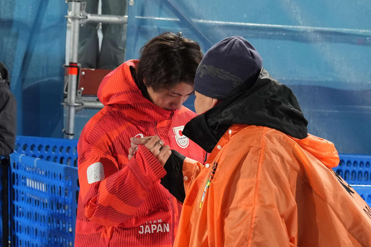銀メダルの二階堂（左）は浮かない表情で父の学さんと握手を交わす（撮影・パオロ　ヌッチ）