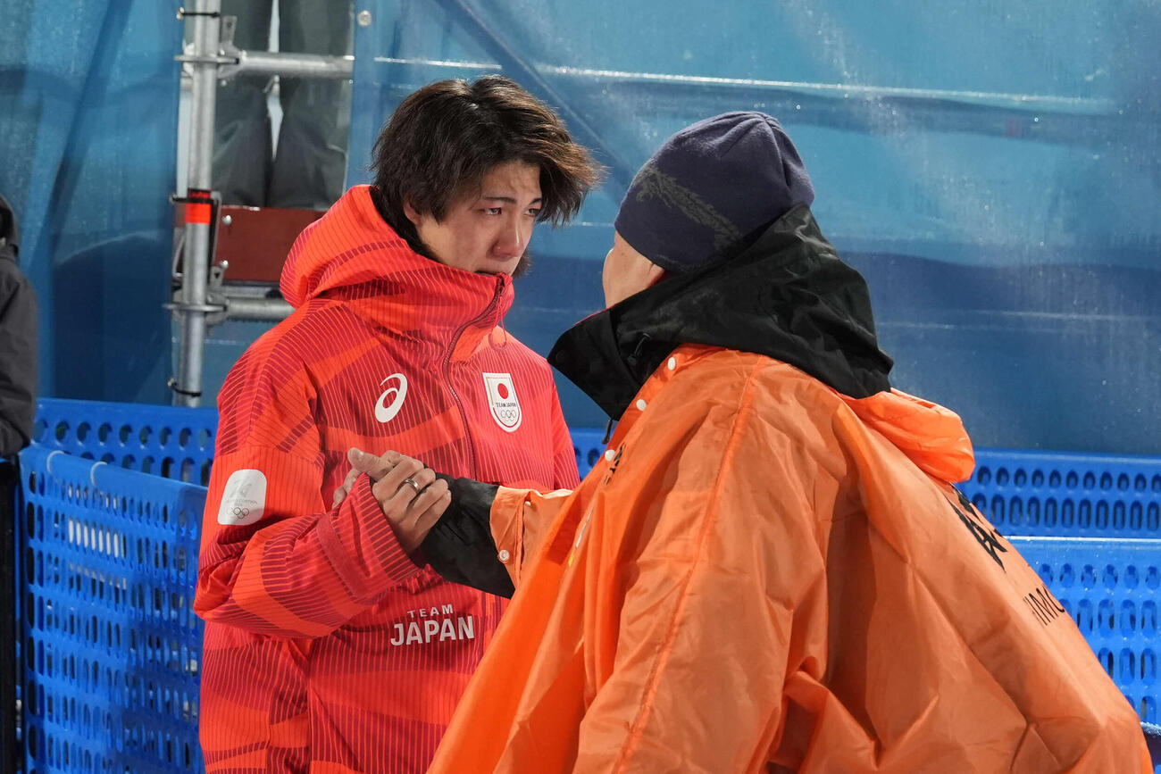 銀メダルの二階堂（左）は厳しい表情で父の学さんと握手を交わす（撮影・パオロ　ヌッチ）