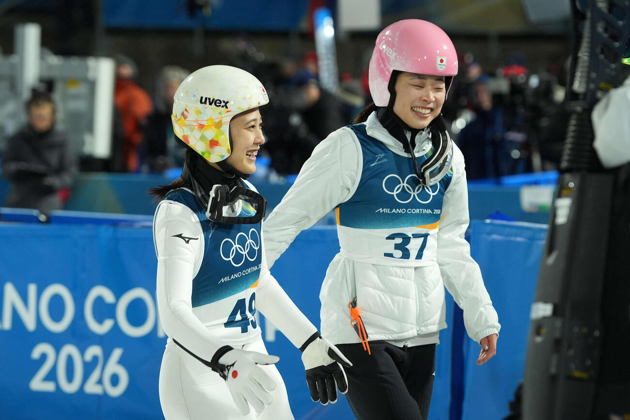 女子個人ラージヒル　飛躍を終え、勢藤（右）と笑顔を見せる丸山（撮影・パオロ　ヌッチ）