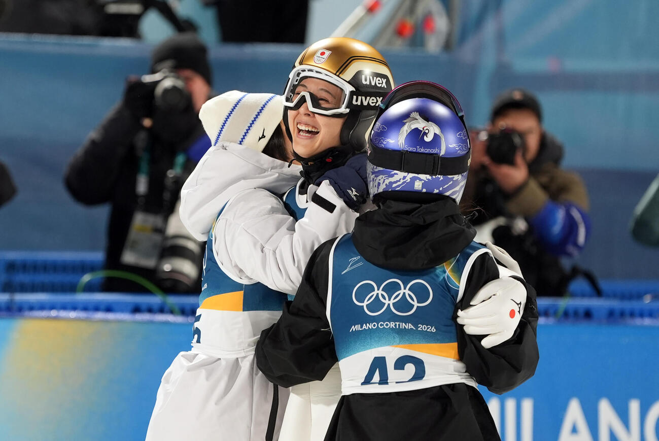 女子個人ノーマルヒルで2回目の飛躍を終え、高梨（右）らと抱き合う丸山（2026年2月7日撮影）