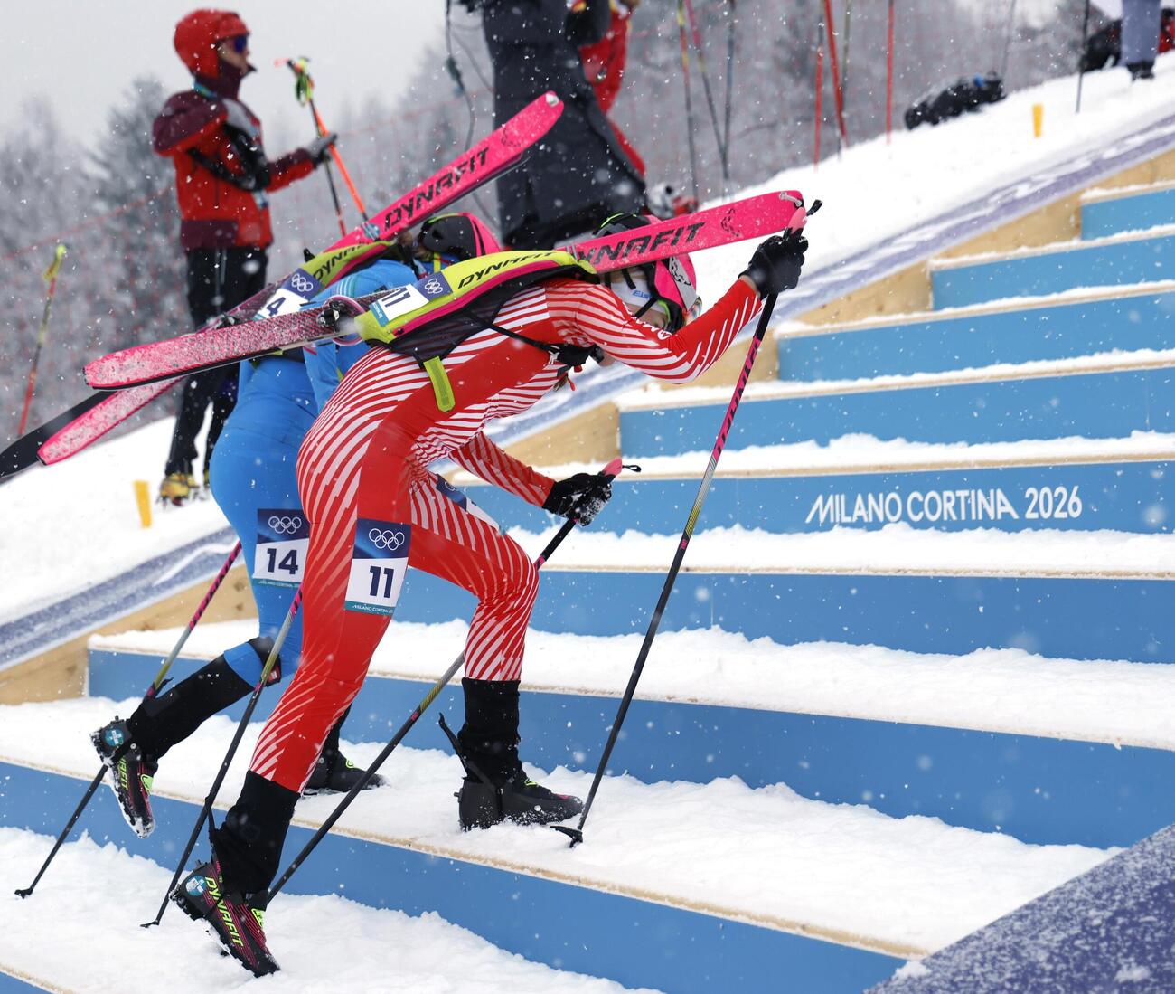 女子スプリント予選　スキー板を背負って力走する選手たち＝ボルミオ（共同）