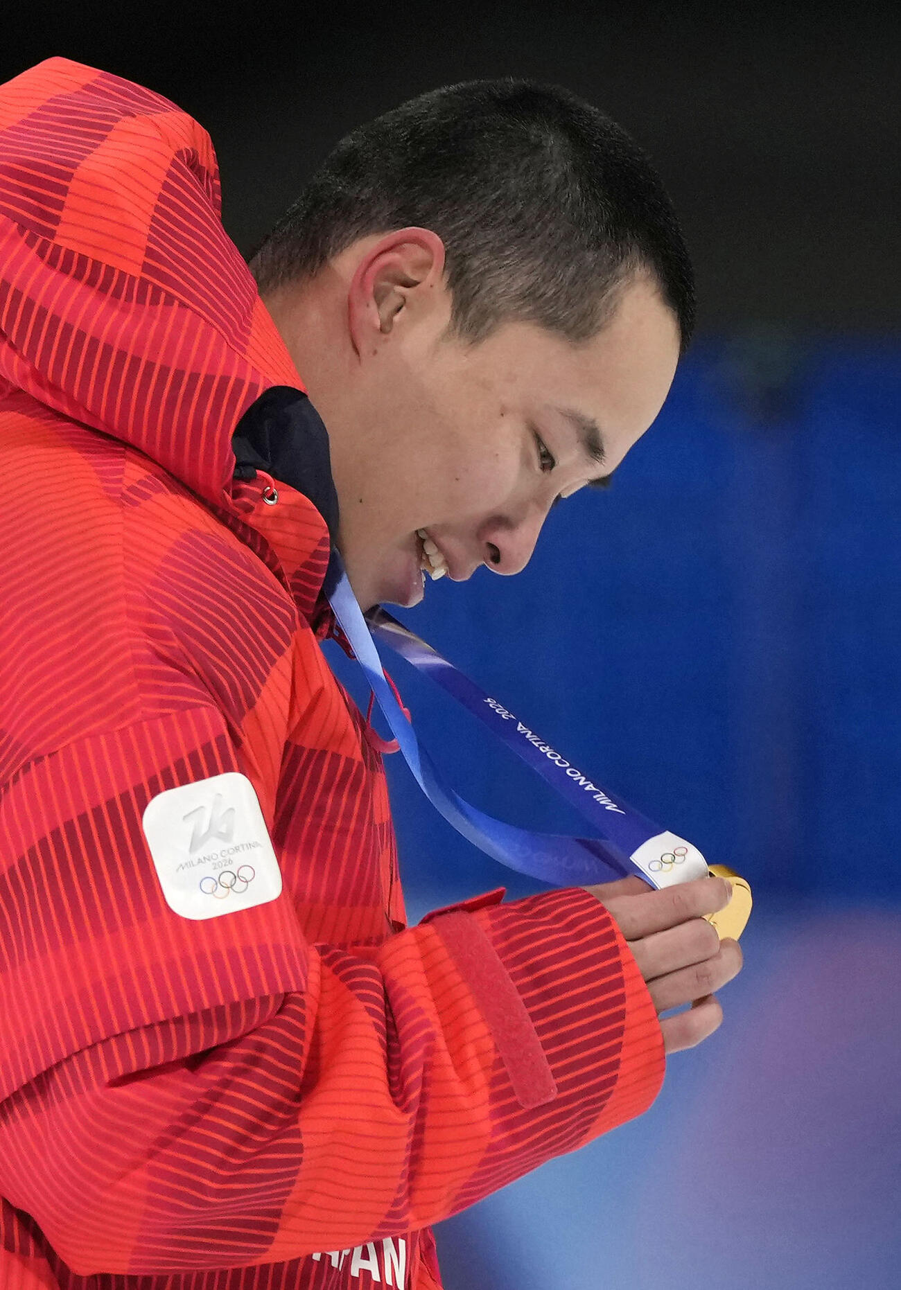 7日、スノーボード男子ビッグエアで獲得した金メダルを見つめる木村葵来（共同）