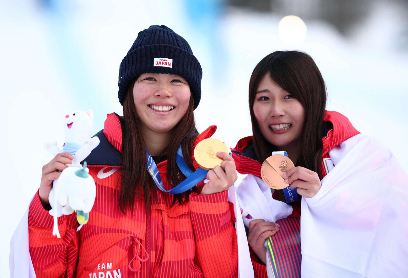 スノーボード女子スロープスタイルで金メダルを獲得し、笑顔を見せる深田茉莉（左）。右は銅メダルの村瀬心椛（ロイター）