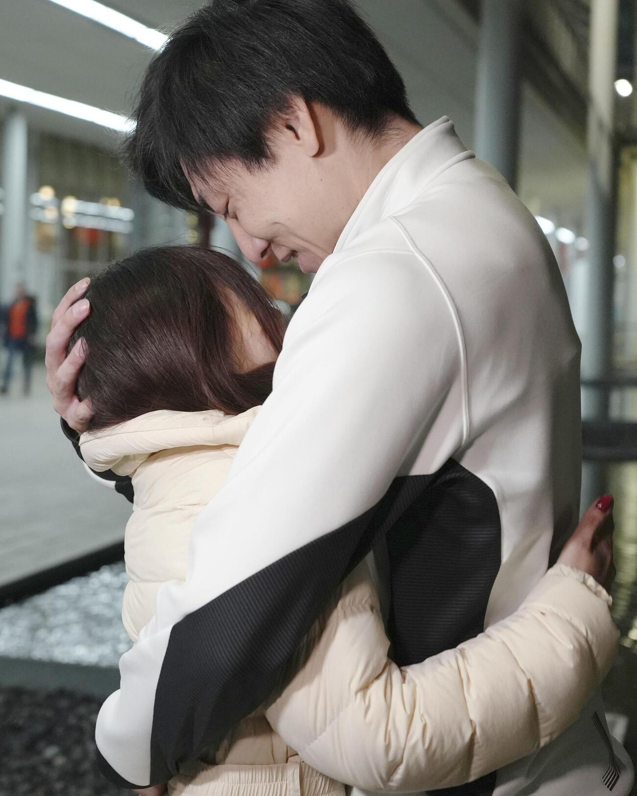 スピードスケート男子500メートルのレース後、妻の吉田夕梨花（左）を抱きしめる新濱立也（共同）