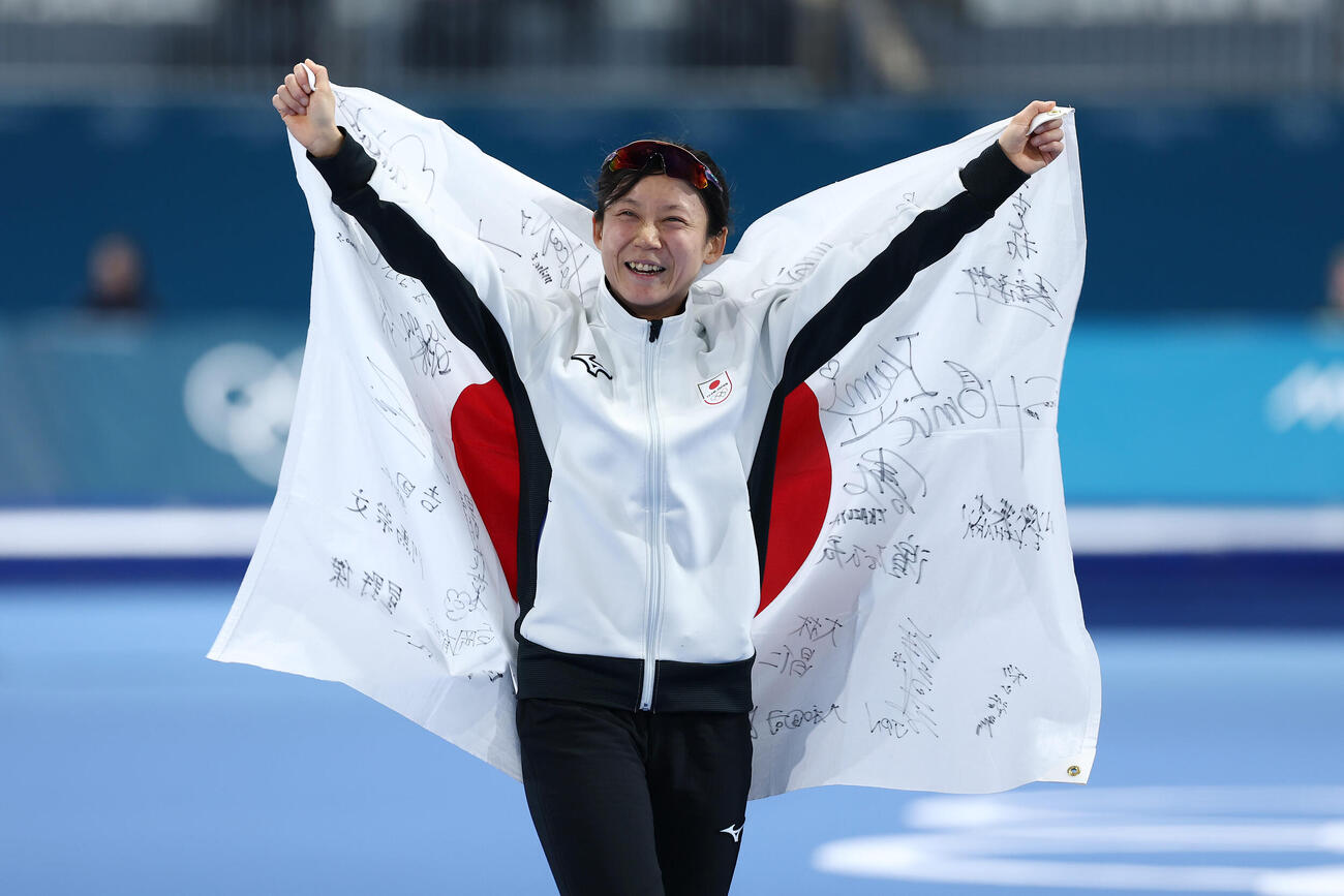 女子500メートルで銅メダルを獲得し、日の丸を先制に笑顔を見せる高木（撮影・前田充）