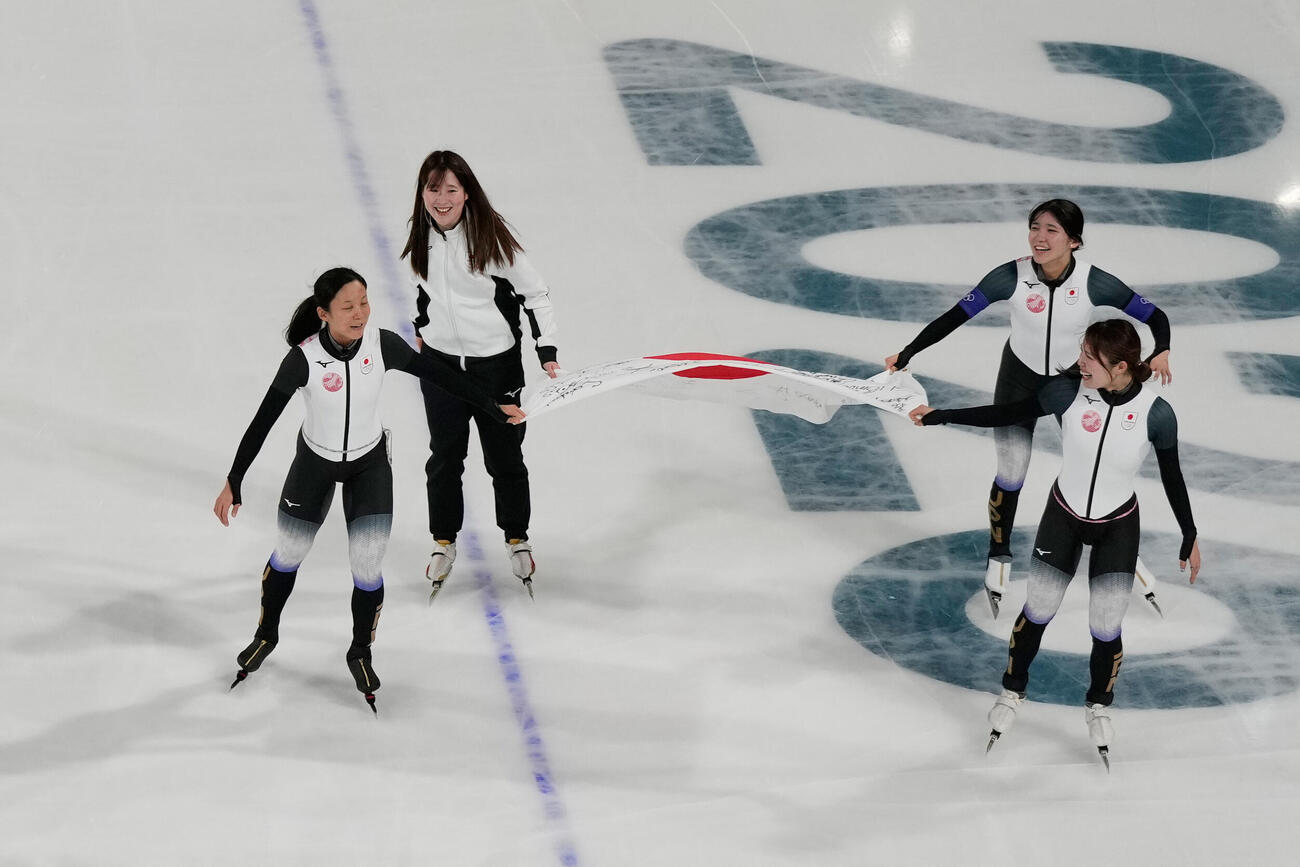 スピードスケート女子団体追い抜き　３位決定戦で勝利し、国旗を持って滑る日本。左から高木美帆、堀川桃香、野明花菜、佐藤綾乃（AP）
