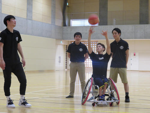 大学体育館での早朝練習でシュートを放つ古沢拓也。見守るスタッフは、左から鍬田直之さん、兵藤智貴さん、絹村広誠さん（撮影・小堀泰男）