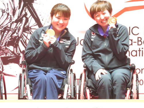 女子WH1－2（車いす）ダブルスで連覇を果たした山崎悠麻（右）と里見紗李奈は金メダルを手に笑顔（撮影・小堀泰男）
