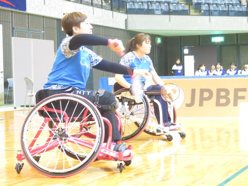 女子WH1－2（車いす）ダブルス決勝　第1ゲーム、サーブを放つ山崎悠麻（手前）と里見紗李奈（撮影・小堀泰男）