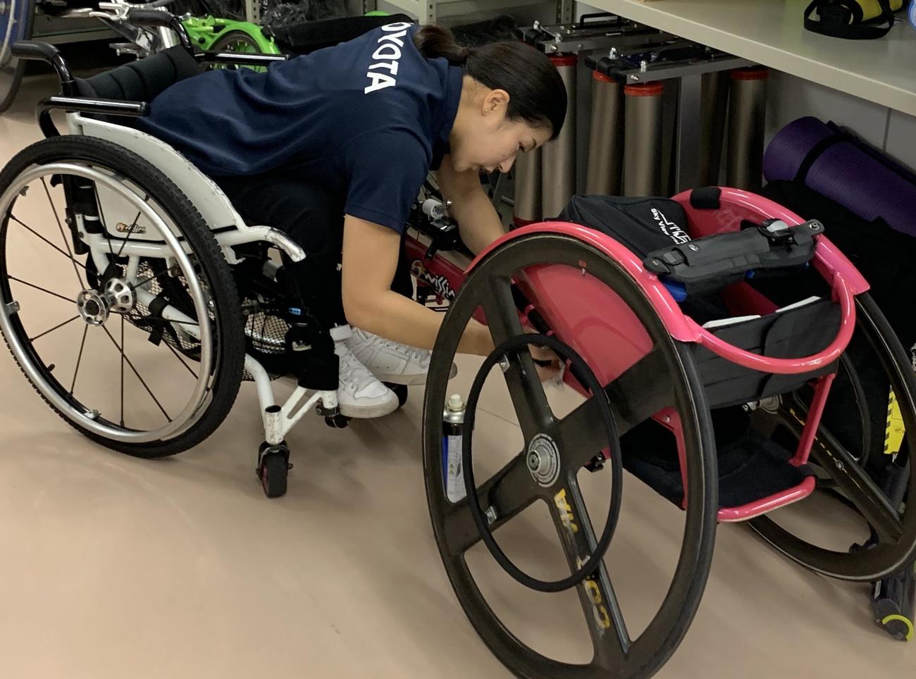 ピンクの愛車のメンテナンスをする村岡桃佳