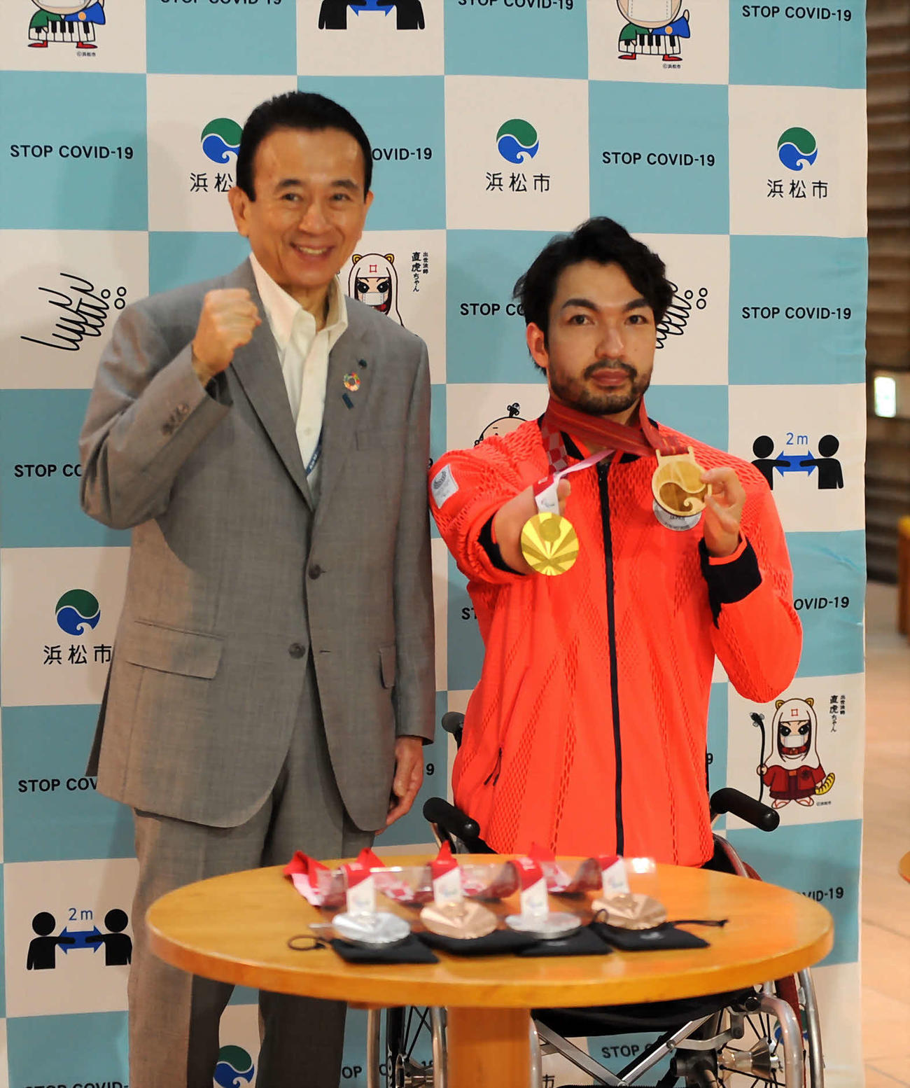 鈴木孝幸（右）は金と木のメダルを掲げて、鈴木康友市長と記念撮影