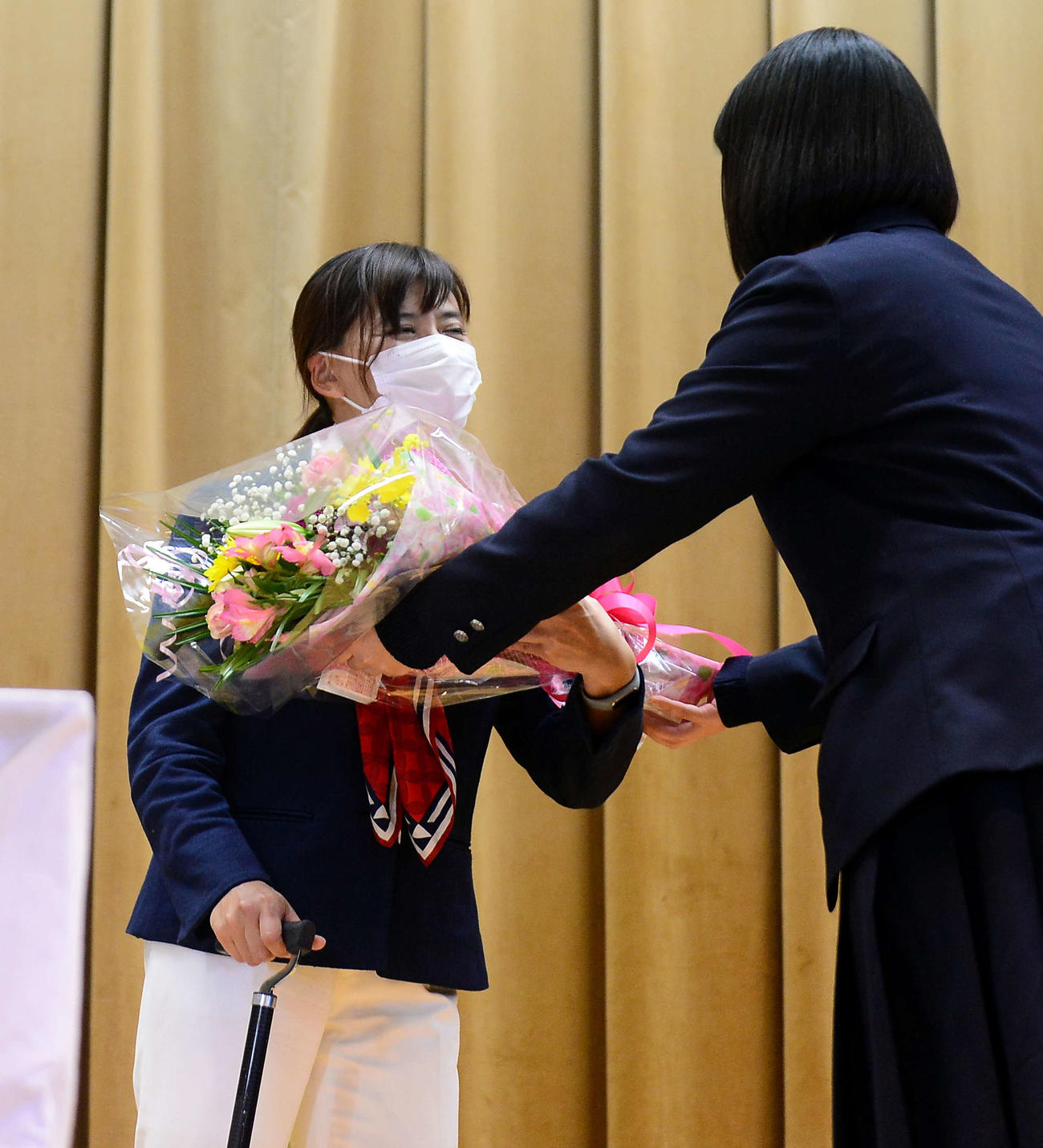 生徒から花束を受け取り、笑顔を見せる杉浦（左）