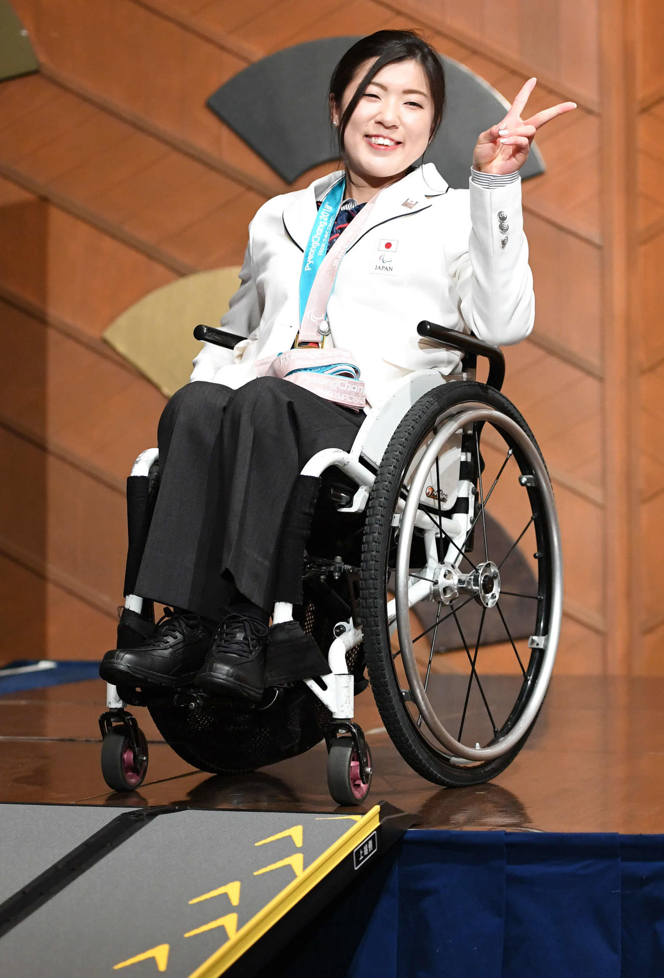 18年３月、平昌パラリンピックの日本選手団解団式・記者会見を終えてＶサインの村岡