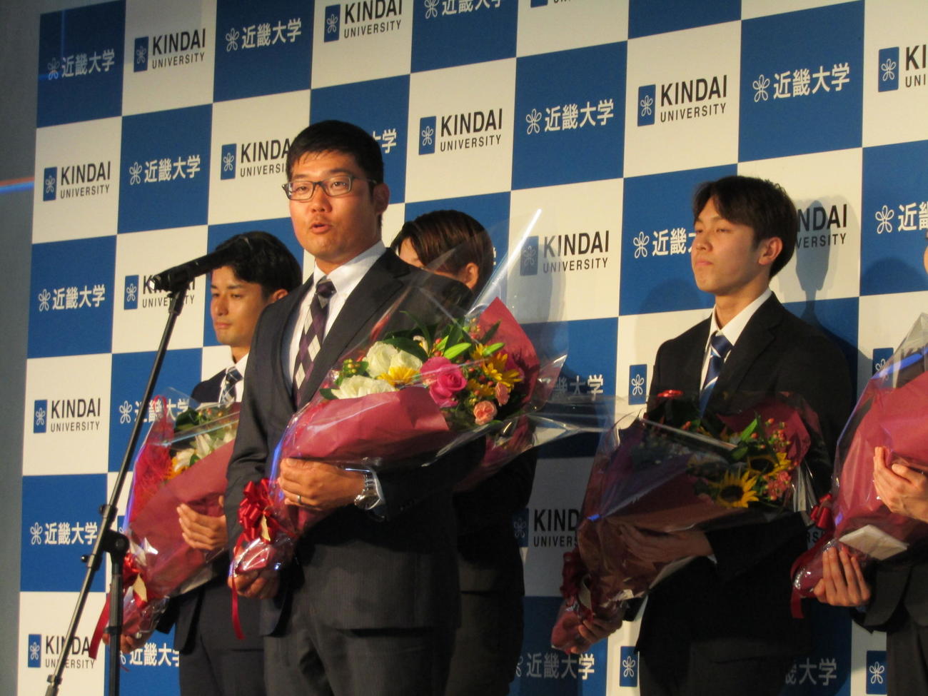 近大の五輪壮行会で選手代表としてあいさつするアーチェリーの古川高晴（手前）
