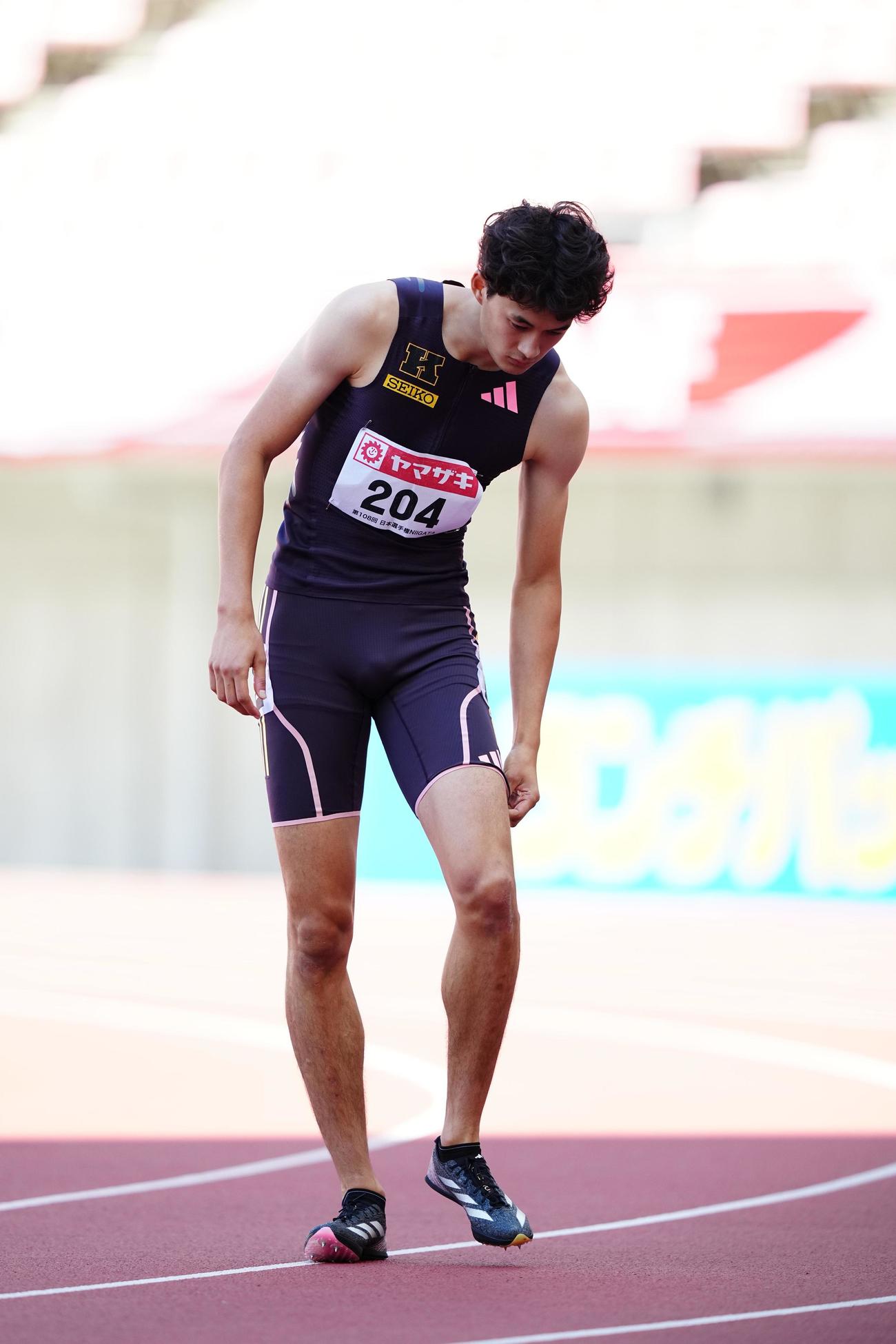 男子110メートル障害予選、ゴール後に左足を気にする豊田（撮影・垰建太）