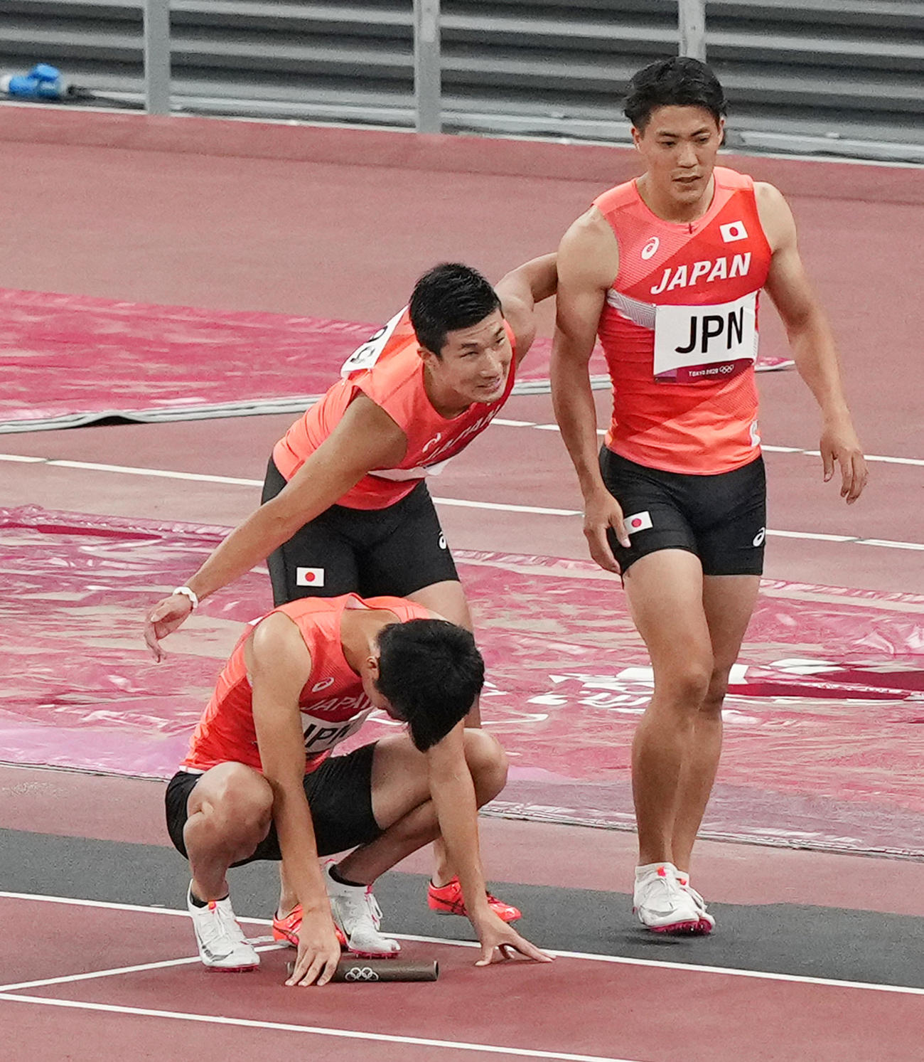 東京五輪の男子400メートルリレー決勝でバトンパスの失敗で失格となり、うなだれる第1走者多田（左）と第2走者山県（右）をなぐさめる桐生（2021年8月6日）