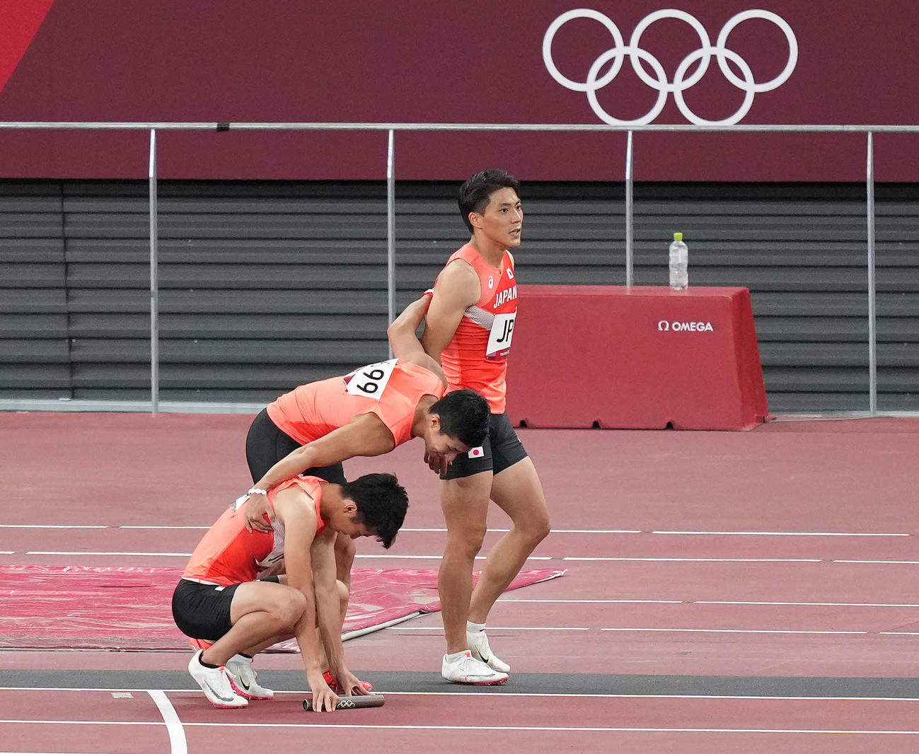 東京五輪男子400メートルリレー決勝　バトンパスができず失格となり、うなだれる多田（左）と山県（右）を励ます桐生（2021年8月6日）