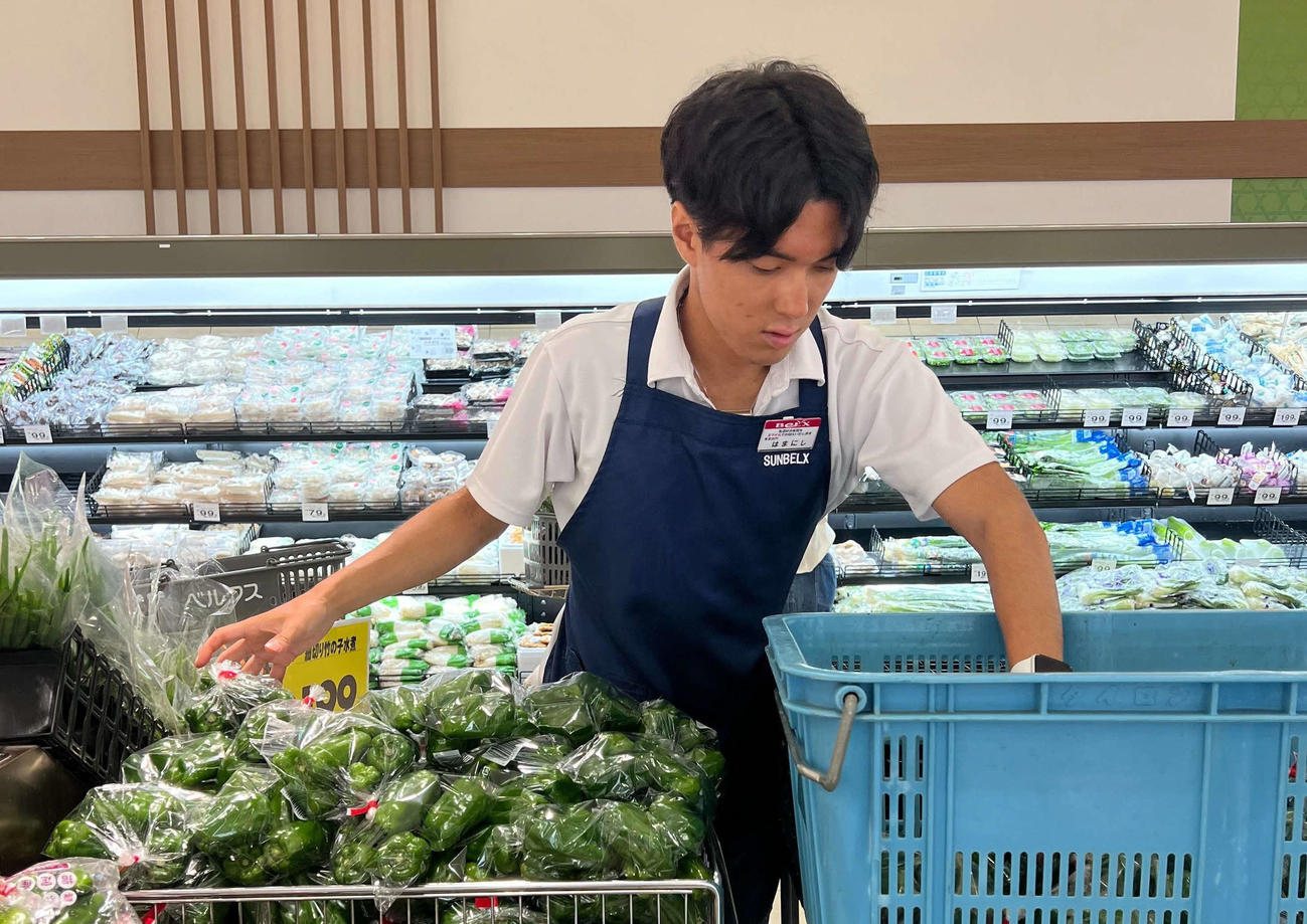 埼玉・草加市内のスーパーベルクスで野菜の品出しをする陸上男子競歩の濱西（サンベルクス提供）