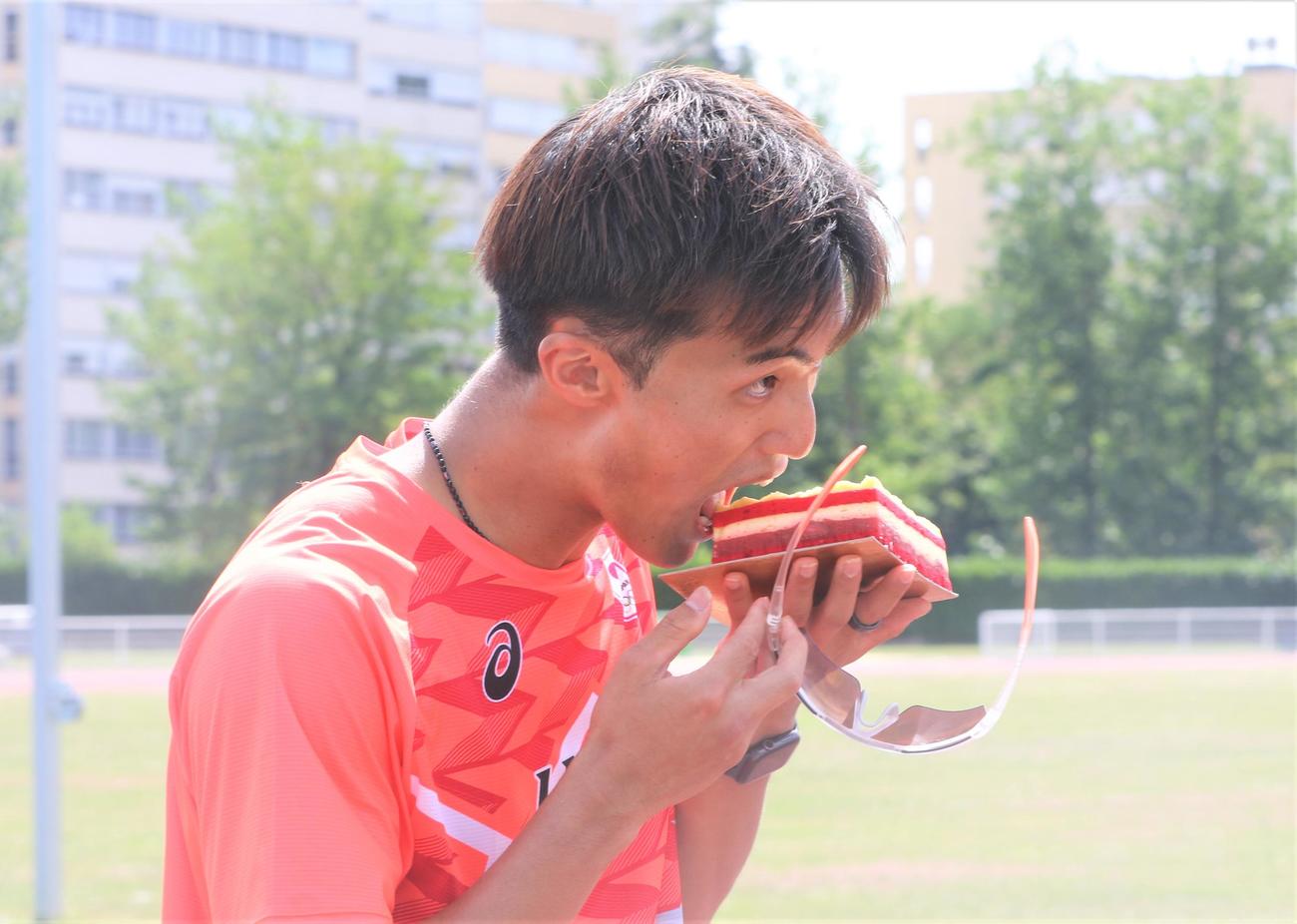 パリ五輪へ向けた事前合宿で誕生日ケーキを送られてかぶりつく陸上男子短距離の柳田（撮影・藤塚大輔）
