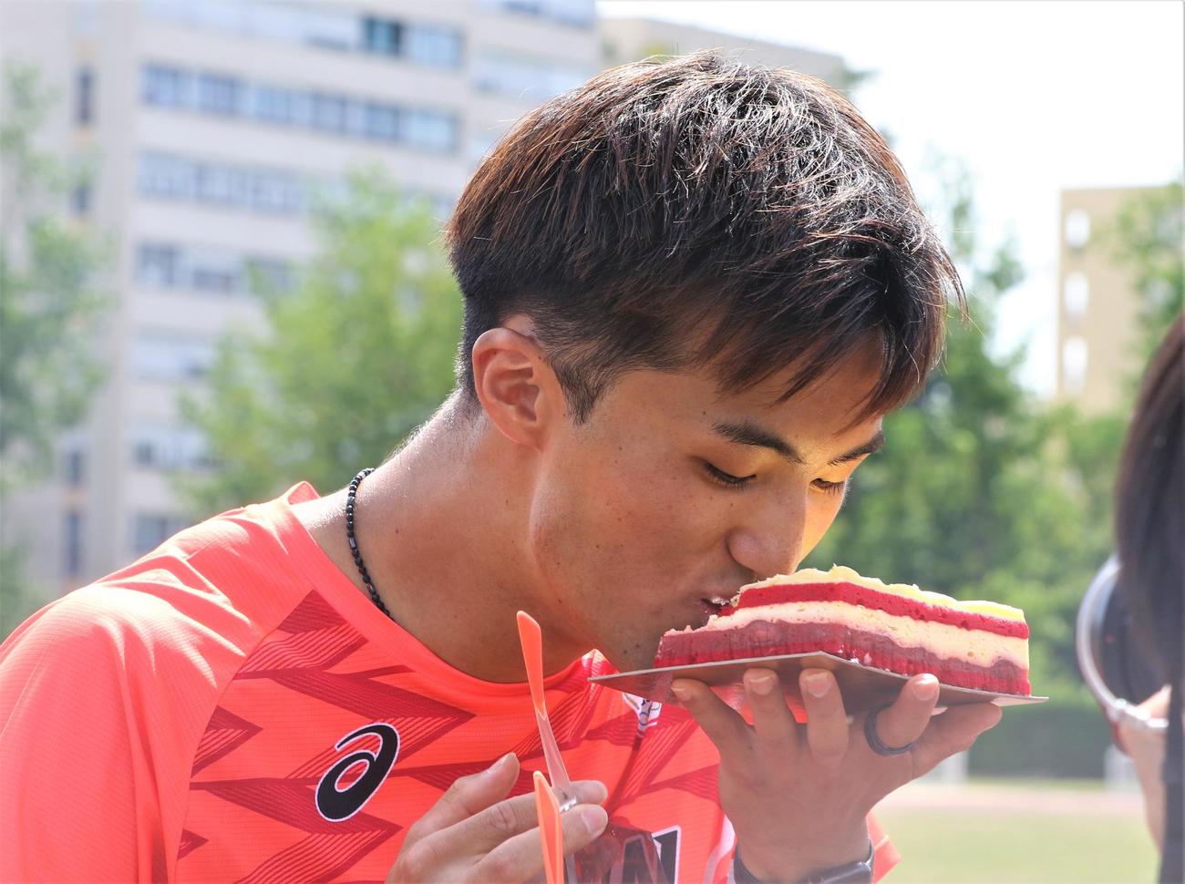 パリ五輪へ向けた事前合宿でバースデーケーキを贈られ、笑顔でかぶりつく陸上男子短距離の柳田（撮影・藤塚大輔）