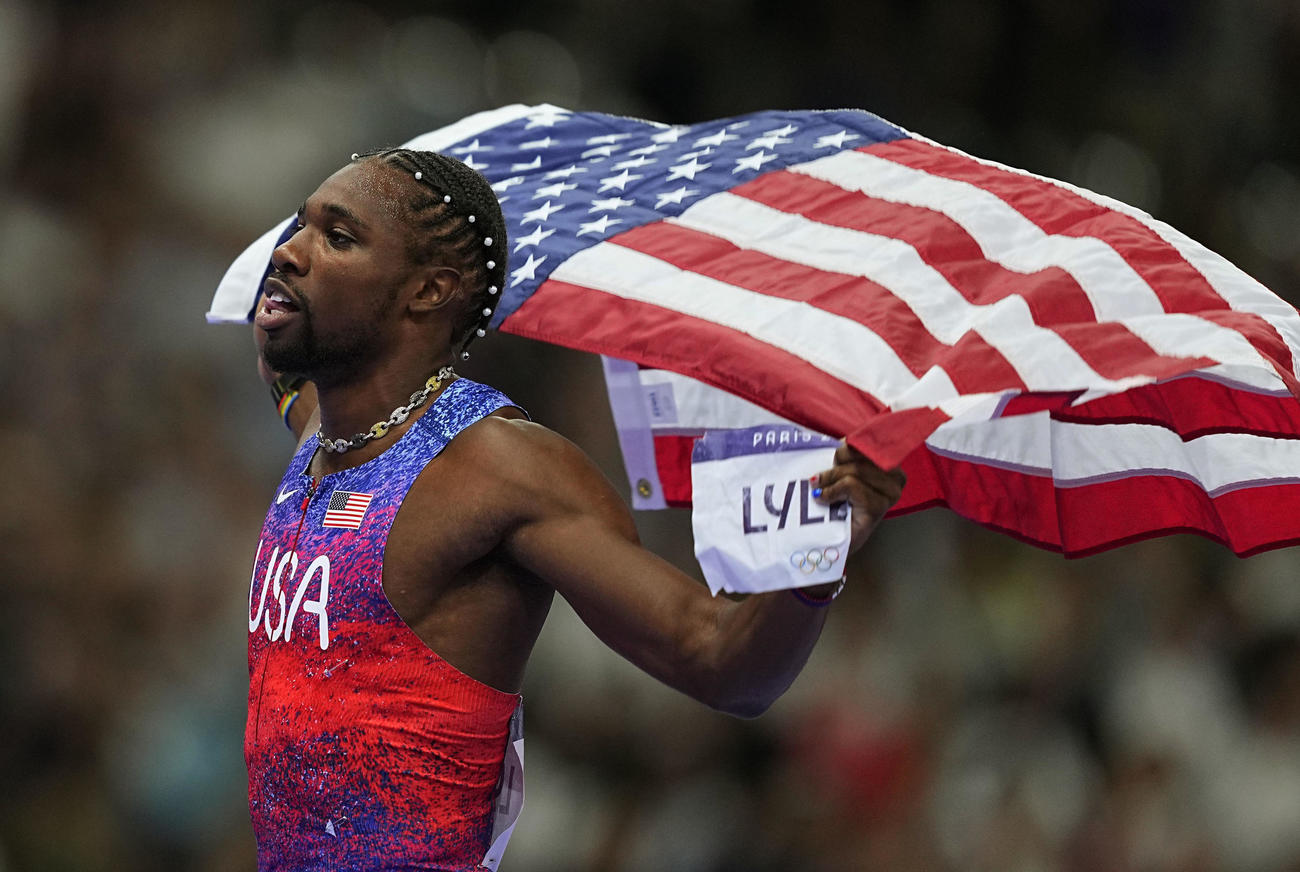 男子100メートルで優勝し、国旗を掲げる米国のライルズ（共同）