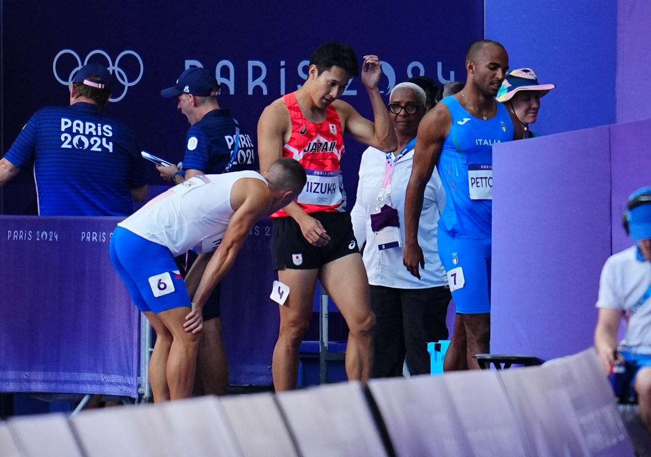 陸上男子200メートル予選、レースを終えさえない表情で引き揚げる飯塚（中央）（撮影・垰建太）