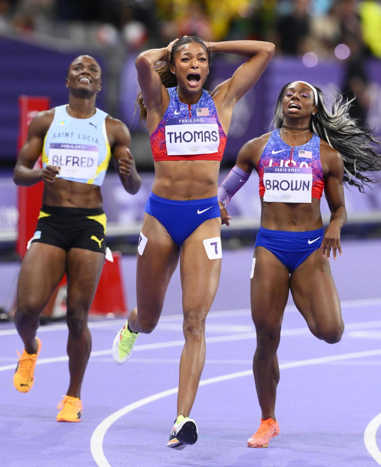 女子200メートルで優勝した米国のトーマス（中央）。左は2位となったセントルシアのアルフレッド（共同）