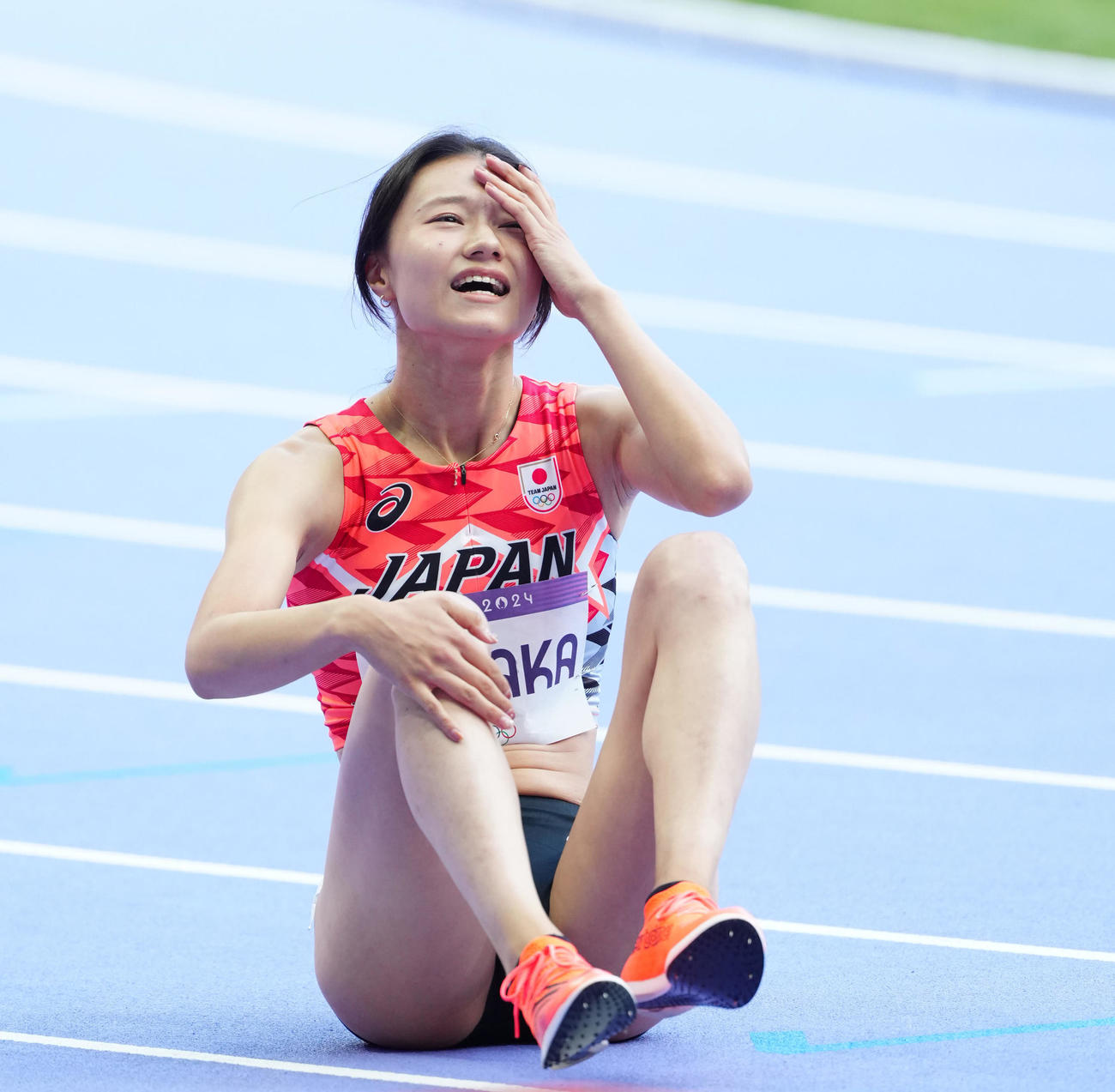 陸上の女子100メートル障害予選後、座り込み、厳しい表情の田中佑（撮影・江口和貴）
