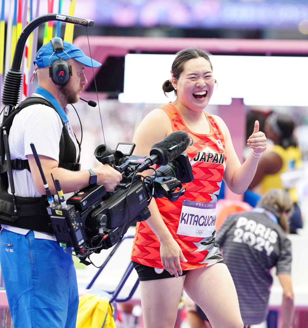 女子やり投げ予選の1投目の試技で決勝進出を決め、サムズアップポーズで笑顔を見せる北口（撮影・江口和貴）