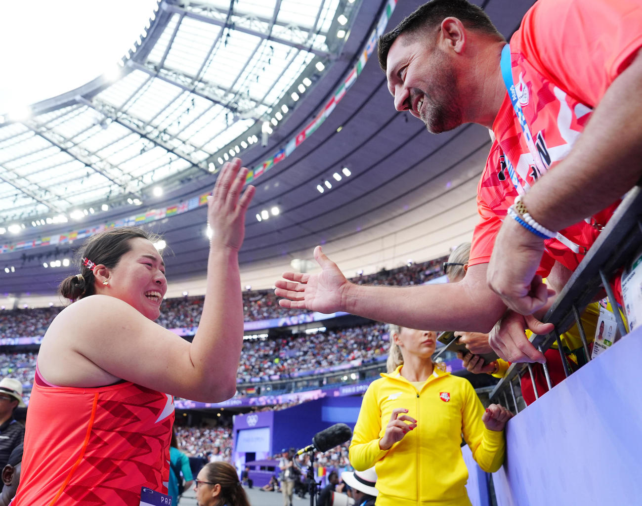 陸上の女子やり投げ予選の1投目の試技で決勝進出を決め、セケラック・コーチ（右）とタッチを交わす北口（撮影・江口和貴）