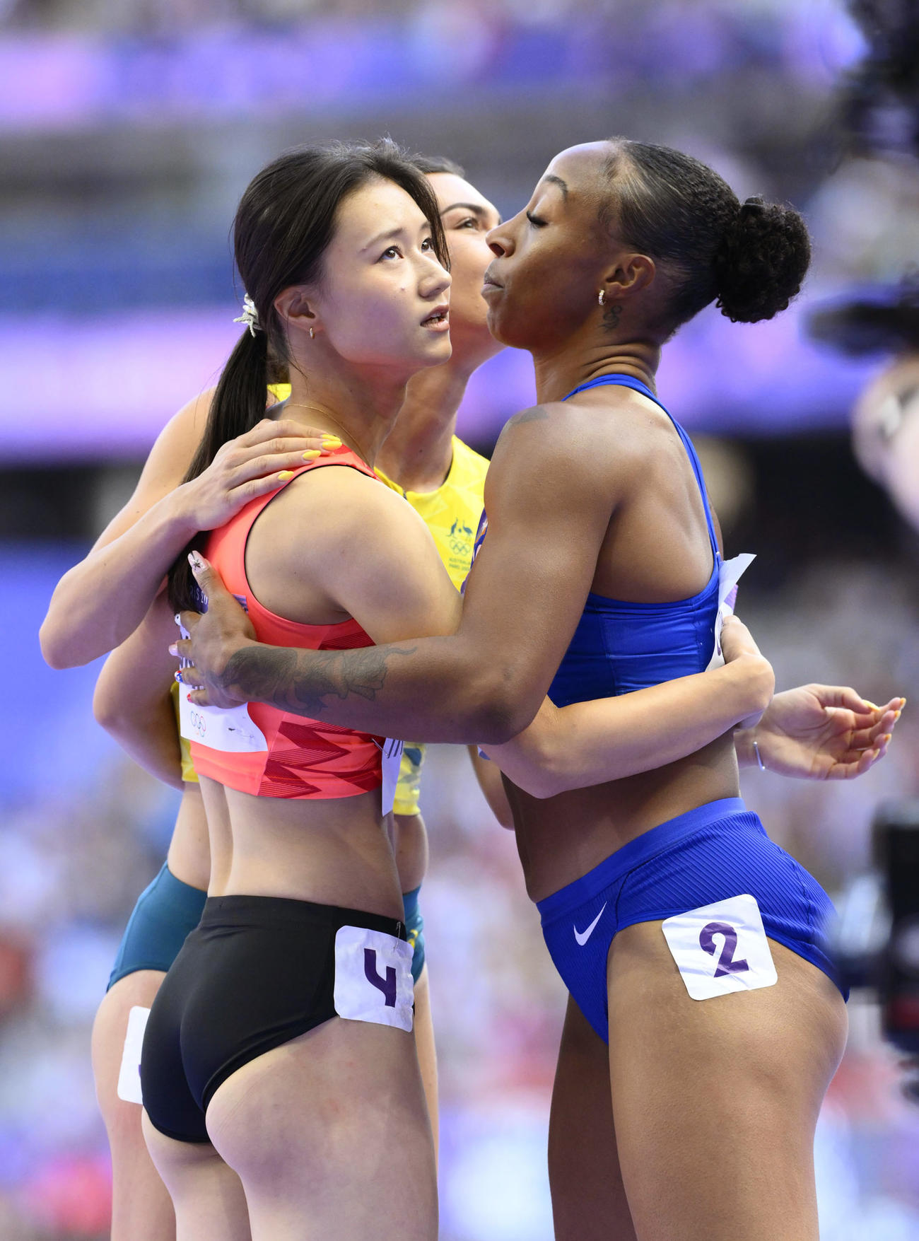 女子100メートル障害予選を終え、健闘をたたえ合う田中佑美（左）（共同）